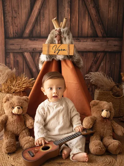 A rustic, woodland-themed first birthday shoot. This little boy is ready to celebrate with his teddy bears and a mini guitar.