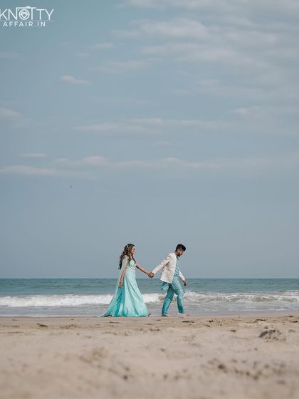 An elegant walk along a pristine beach. The bride's flowing turquoise gown against the blue sky and sea creates a stunning, cinematic image.