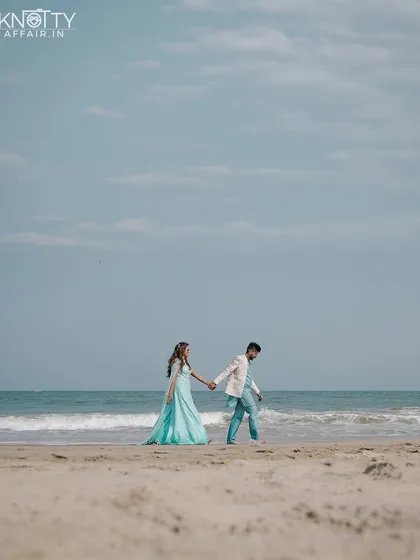 An elegant walk along a pristine beach. The bride's flowing turquoise gown against the blue sky and sea creates a stunning, cinematic image.