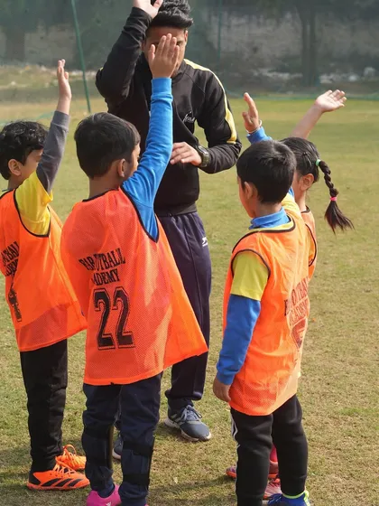 A coach high-fiving young players. Our 1-on-1 training focuses on each child's unique needs, ensuring personalized guidance.