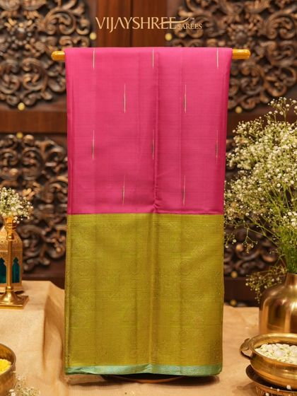 A luxurious pink and green Kanjivaram silk saree with a striking gold border.