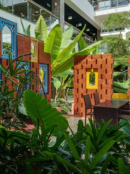 A vibrant courtyard at SAP Labs, inspired by traditional Rajasthani architecture. The design uses colorful walls, brick jali screens, and lush tropical planting to create a unique and culturally rich breakout space for employees.