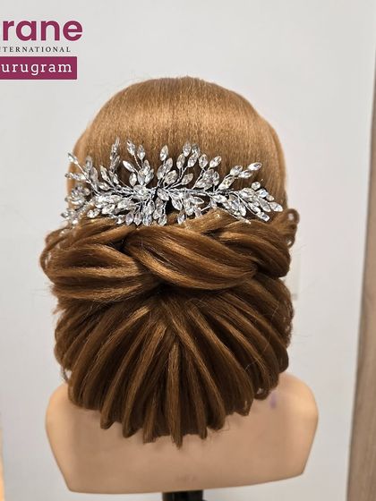 The back view of the elegant low bun, adorned with a crystal hairpiece. I teach students how to incorporate accessories seamlessly into their hairstyles.