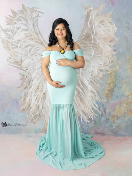 An angelic portrait. The combination of the soft blue gown and the dramatic white wings creates a truly ethereal and breathtaking image.