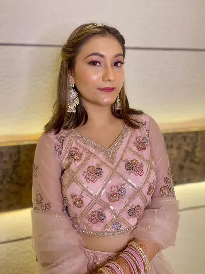 A soft and pretty party makeup look for a client in a pink lehenga. The makeup features pink eyeshadow and a matching lip color.