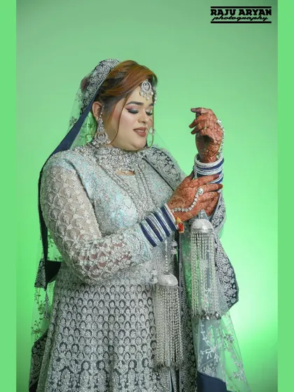 The bride admires her kalire, a significant part of the wedding ceremony. This shot focuses on the tradition and the beauty of her henna-adorned hands.