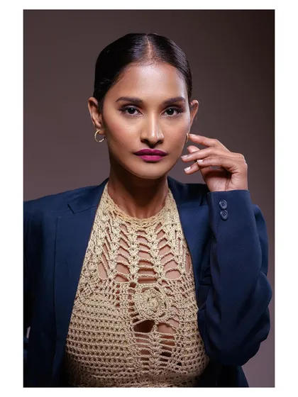 A close-up that highlights the model's strong features and the detailed texture of the crochet top.