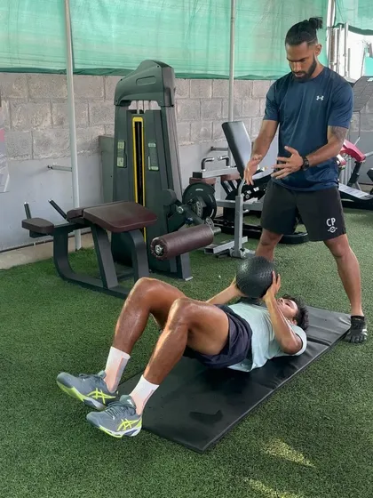This image shows an athlete performing a bridge drop with a medicine ball throw. This advanced drill challenges hamstring control and core stability while requiring the athlete to disassociate upper and lower body movements, a key skill in many sports.