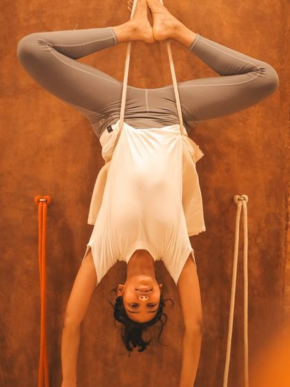 Our training includes extensive work with the Iyengar yoga wall. A student practices a supported inversion, using the ropes to build confidence and experience the benefits of being upside down without strain on the neck or shoulders.