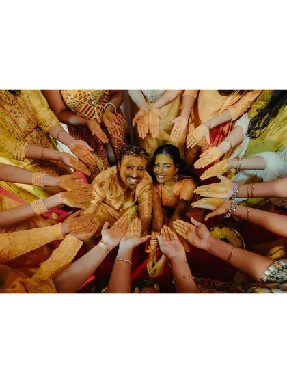 The Haldi ceremony is all about vibrant colors and pure happiness. This creative shot, with all hands reaching in to bless the couple, captures the collective joy and community spirit that makes Indian pre-wedding rituals so special.