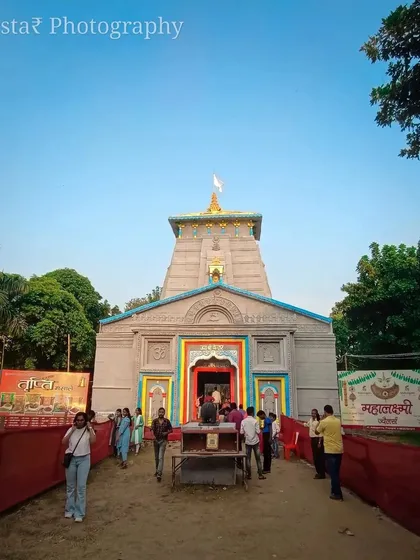 A daytime, ground-level shot of the Kedarnath-themed pandal. This shows how the structure looks in natural light, capturing the colors and the people visiting during the day.