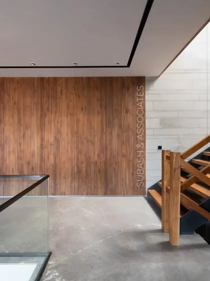 The contrast between warm veneer panels and cool tile-clad walls creates emphasis. The glass and wood railings resonate with each other in form and order.