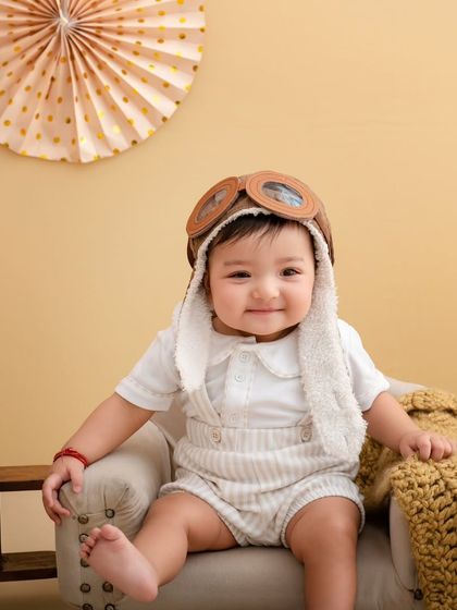 Our little pilot is all smiles, sitting comfortably in his mini armchair, ready for his next flight of imagination.