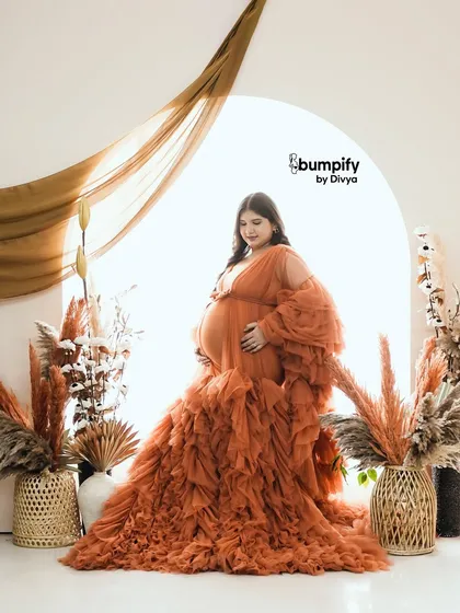 Another beautiful solo shot, this time with the mom-to-be standing and looking towards the light. The flowing fabric of the gown creates a sense of grace and movement.