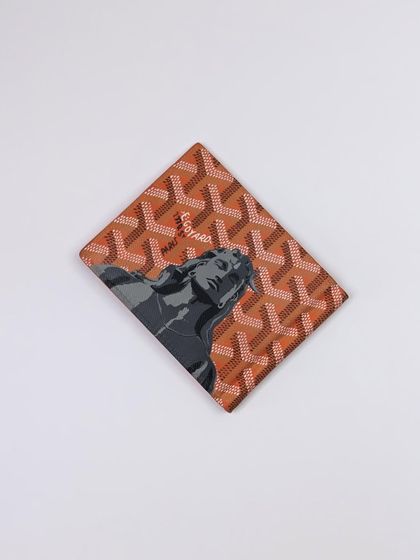 The finished Goyard money clip, fully restored and customized. The monochrome Adiyogi artwork provides a striking contrast against the vibrant orange pattern.