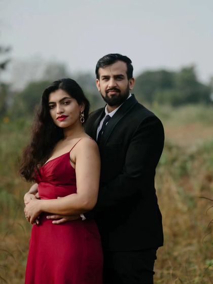 A classic portrait pose that feels both elegant and strong. The natural, earthy tones of the landscape complement their formal attire in this outdoor pre-wedding session.