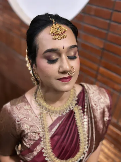 The details make all the difference in a traditional look. This close-up shows a soft brown and maroon smokey eye, a classic bindi, and traditional jewellery like the nose ring (nath). It’s these elements that come together to create an authentic Muhurtham look.