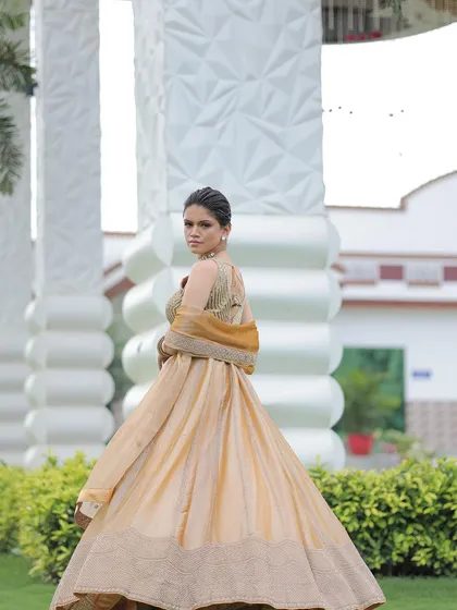 A back view of the gold lehenga, highlighting the design of the embellished blouse.
