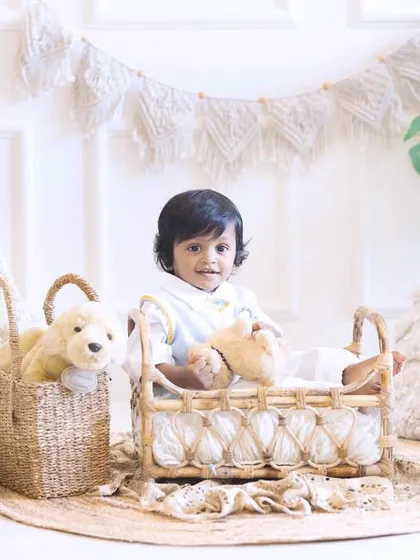 Hello, one. This little boy is celebrating his first birthday surrounded by a breezy, boho-themed setup with natural textures and props.