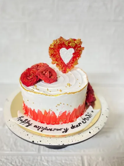 A full view of the romantic red and white anniversary cake.