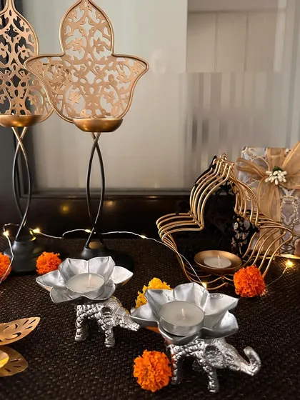 A collection of my festive T-light holders and decor. You can see the silver elephant T-lights, tall Hamsa holders, and other beautiful pieces that are perfect for illuminating your home during celebrations.