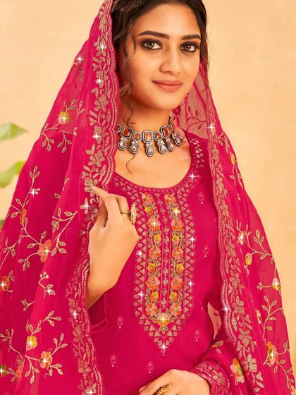 A rani pink salwar kameez that's sure to turn heads. The colorful thread embroidery and sequin work on the neckline and dupatta are just stunning.