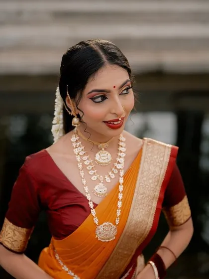 A beautiful portrait of a model in a traditional saree, looking away from the camera. The soft light and her pose create a classic and contemplative mood.