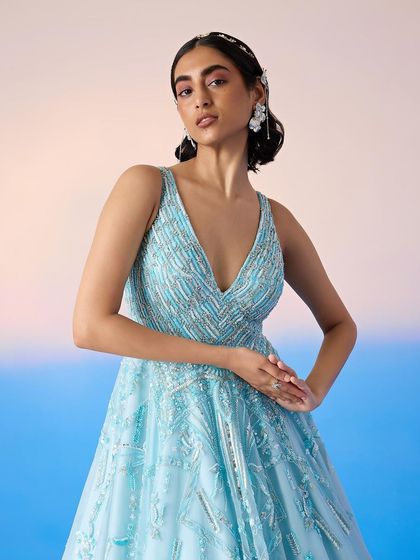 A close-up of the embellished bodice of the blue ballgown, revealing the detailed beadwork and flattering V-neckline.