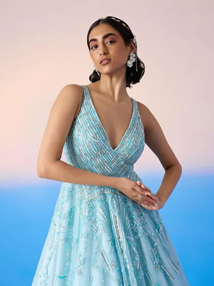 A close-up of the embellished bodice of the blue ballgown, revealing the detailed beadwork and flattering V-neckline.