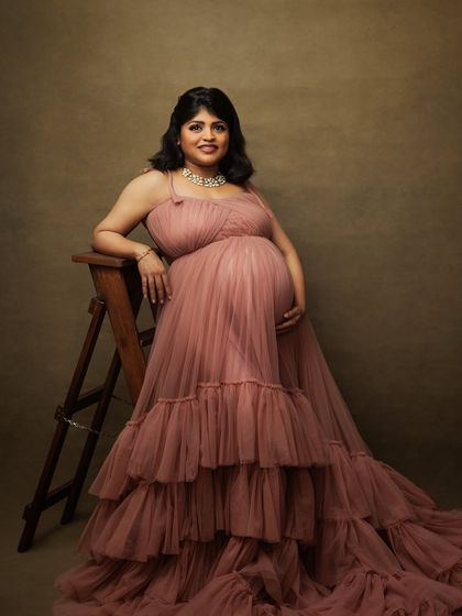 A full-length view of the pink ruffled gown, highlighting its soft color and voluminous texture.