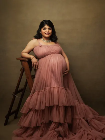 Posing with a rustic ladder, this mother-to-be looks like a character from a classic painting. The ruffled gown adds texture and drama.