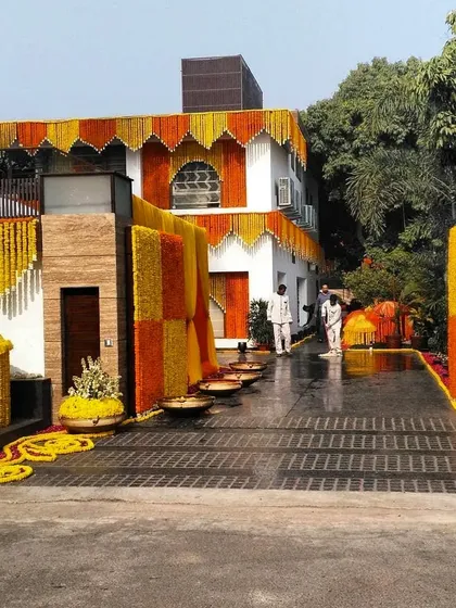 For large-scale home events, I can decorate the entire exterior of the house. This decoration for a wedding function uses thousands of fresh marigold garlands to create a grand and traditional welcome.