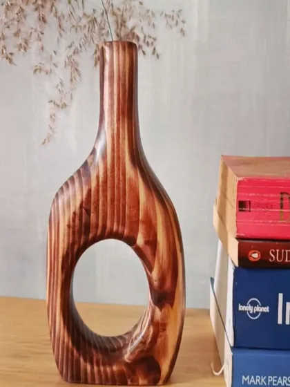 This hand-carved wooden vase, with its unique cutout design and rich wood grain, is a piece of art in itself. It's perfect for holding dried flowers or standing alone as a sculpture.