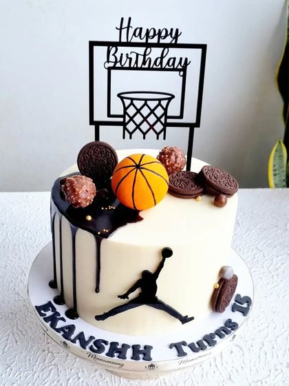 A basketball-themed drip cake. This design combines a clean buttercream finish with a chocolate drip, Oreo cookies, and a fondant basketball.