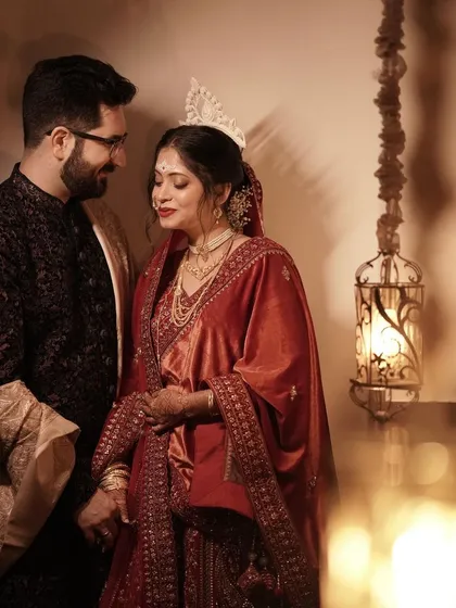 A beautiful portrait of a Bengali bride, showcasing her traditional 'mukut' and stunning red Benarasi saree. We plan weddings across various cultures with attention to every detail.