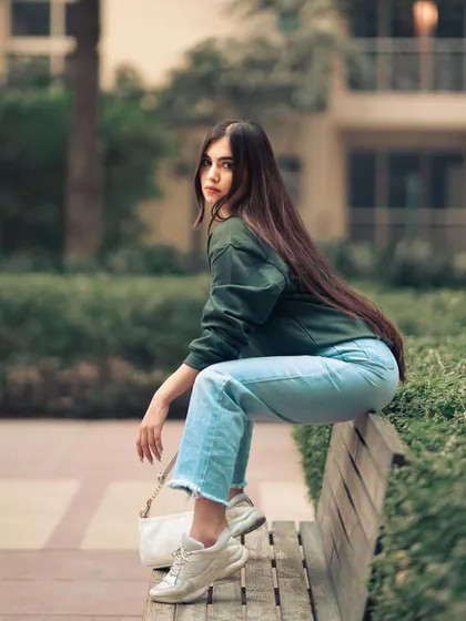 A casual portrait on a park bench. The candid, over-the-shoulder look feels spontaneous and full of personality.