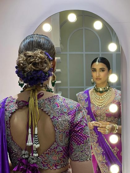 A view from the back, showing the intricate hairstyle with a floral bun that matches the purple outfit. This demonstrates my collaborative approach with hair stylists to create a complete, cohesive look.