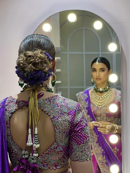 A view from the back, showing the intricate hairstyle with a floral bun that matches the purple outfit. This demonstrates my collaborative approach with hair stylists to create a complete, cohesive look.