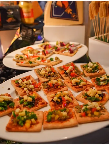 An assortment of savoury crackers topped with fresh vegetables and olives, a perfect light bite for a Diwali party or any festive gathering.