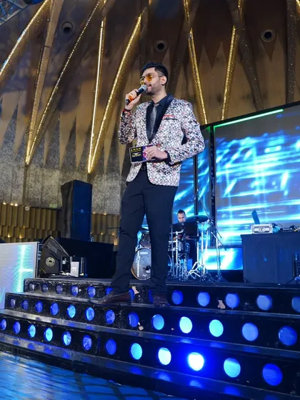 Standing tall on a multi-level stage, ready to get the party started. The grander the stage, the bigger the energy I bring to your event.