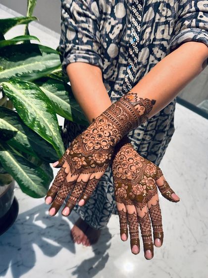 A different pose showing the flow of the mandala design from the back of the hand down to the fingertips, with each line carefully placed.