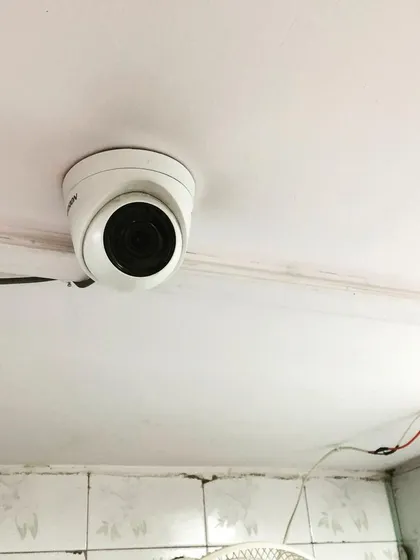 An indoor dome camera installed on a ceiling, providing a wide-angle view of the room.