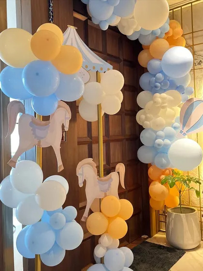 The whimsical theme extended to the entrance, with a beautiful balloon arch and hanging carousel horse cutouts to welcome guests into the celebration.