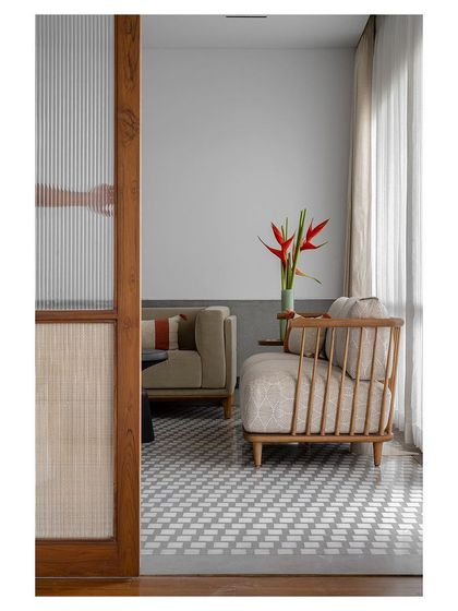 A detail of a spindle-back armchair and sheer curtains, creating a light and airy seating area.