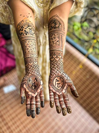 This bridal henna for Jeena features a variety of motifs, including a heart with a peacock on one palm and the sacred 'Om' symbol on the other, reflecting her personal beliefs.