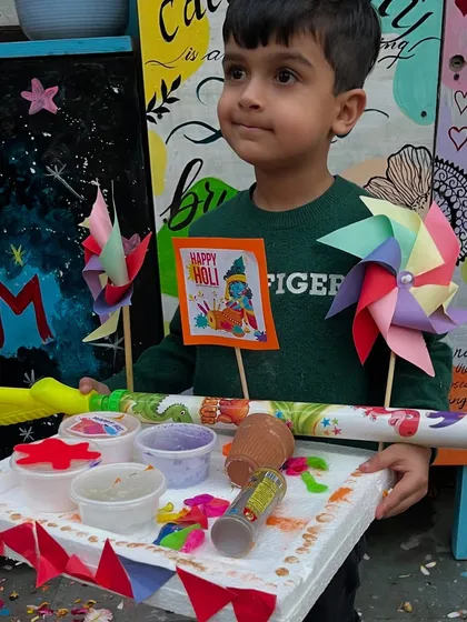Holding his decorated pichkari and Holi tray, this little one is all set for a fun and colorful celebration.