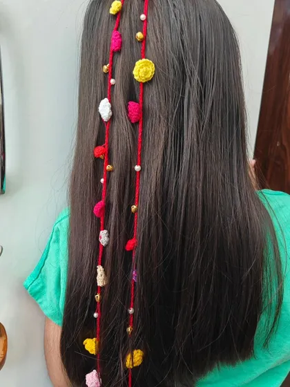 A close-up of my colorful hair extension, featuring tiny flowers, beads, and shells. It's a perfect example of how I combine different elements to create a piece that is full of detail and character.