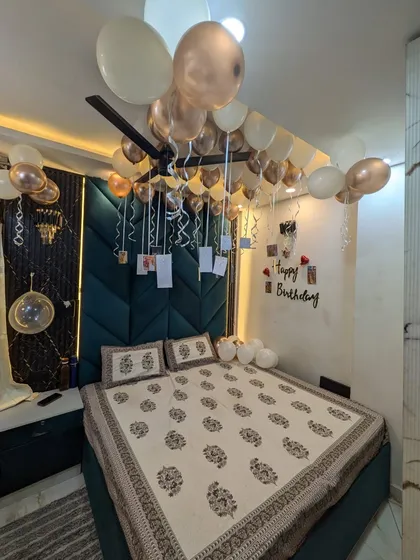 The full view of the decorated bedroom, showcasing the elegant teal headboard complemented by the rose gold and white balloons.