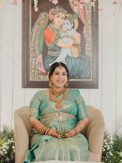 Another portrait of this glowing bride. The makeup is kept fresh and luminous, ensuring she looks perfect from every angle against the traditional backdrop.