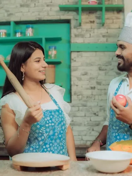 Love is cooking up something beautiful! This couple shares a laugh in a quirky kitchen setting, a perfect example of a themed pre-wedding shoot that reflects shared interests and creates fun, natural interactions.